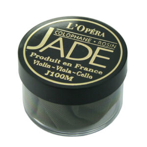 A round container of L'Opéra Jade rosin for violin, viola, and cello. The black lid has gold text with product and brand information in French and English. The rosin is visible through the transparent base.